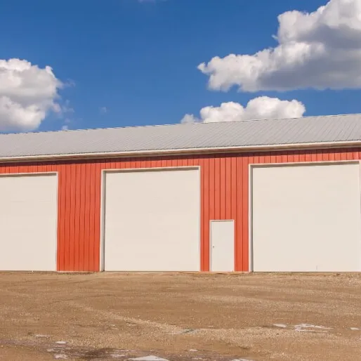 Red steel farm building with large overhead doors