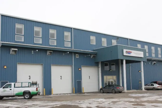 Steel building with service bays and a work truck parked out front
