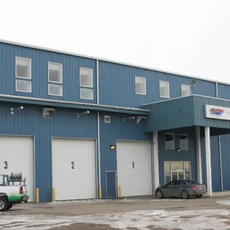 Steel building with service bays and a work truck parked out front