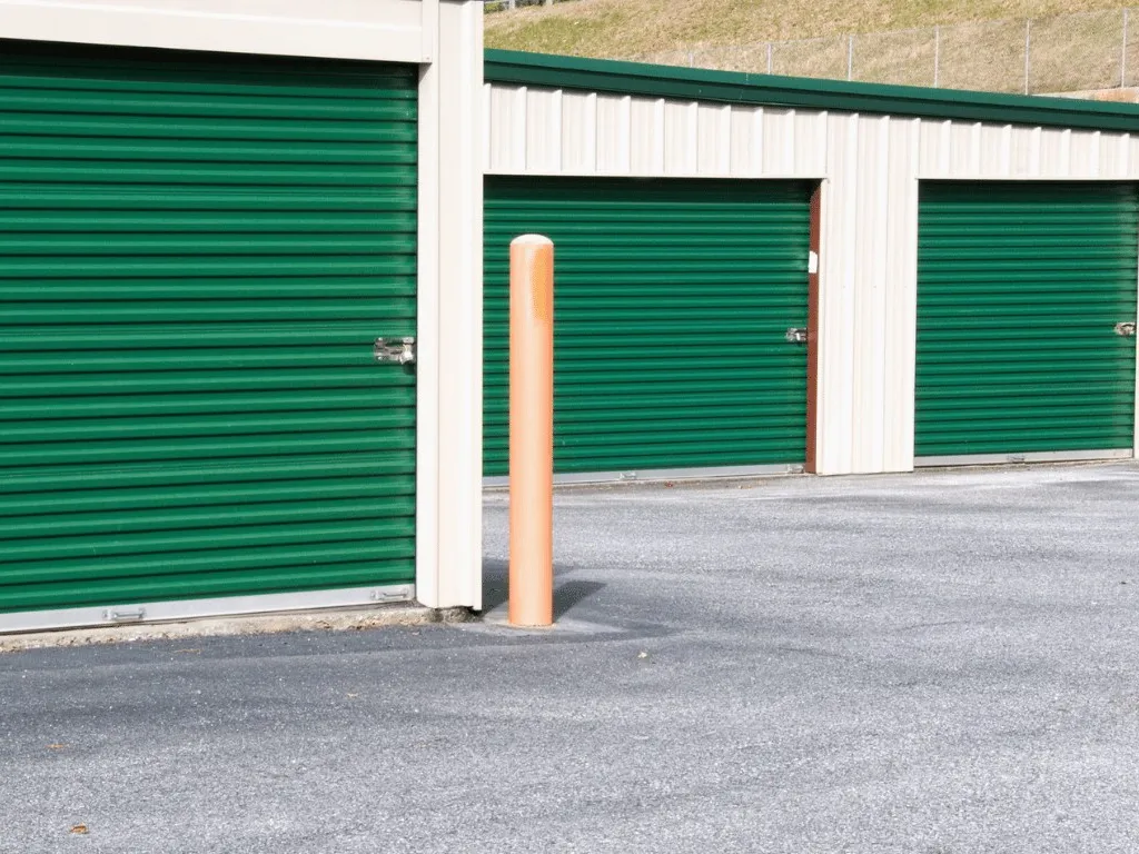 Steel mini-storage units with green roll-up doors