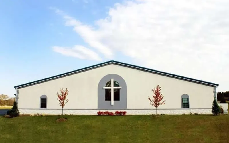 White steel church building with a cross window