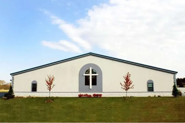 White steel church building with a cross window