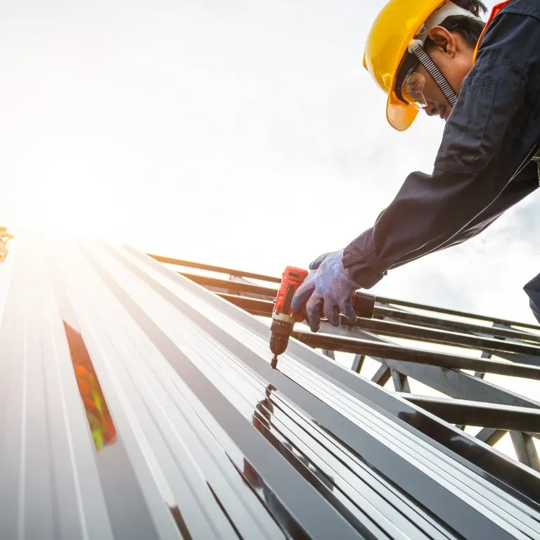 Installer fastening steel roof panels